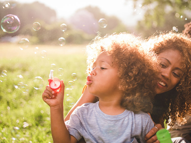 Mother and Boy blowing clourful bubbles